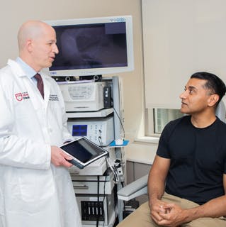Philip LoSavio, MD with a male patient in a clinic room. 