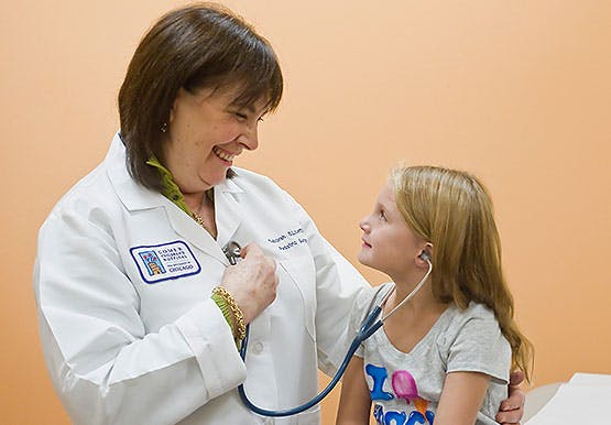 Pediatric surgeon Deborah Leoff, MD, showing a patient a sthethoscope