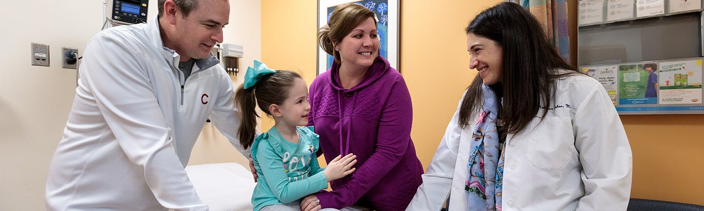 Dr. Melissa Tesher talks with Michael and Jessica Mulcahy and their daughter Brynn in an exam room at the Rheumatolgy Clinic at Comer.